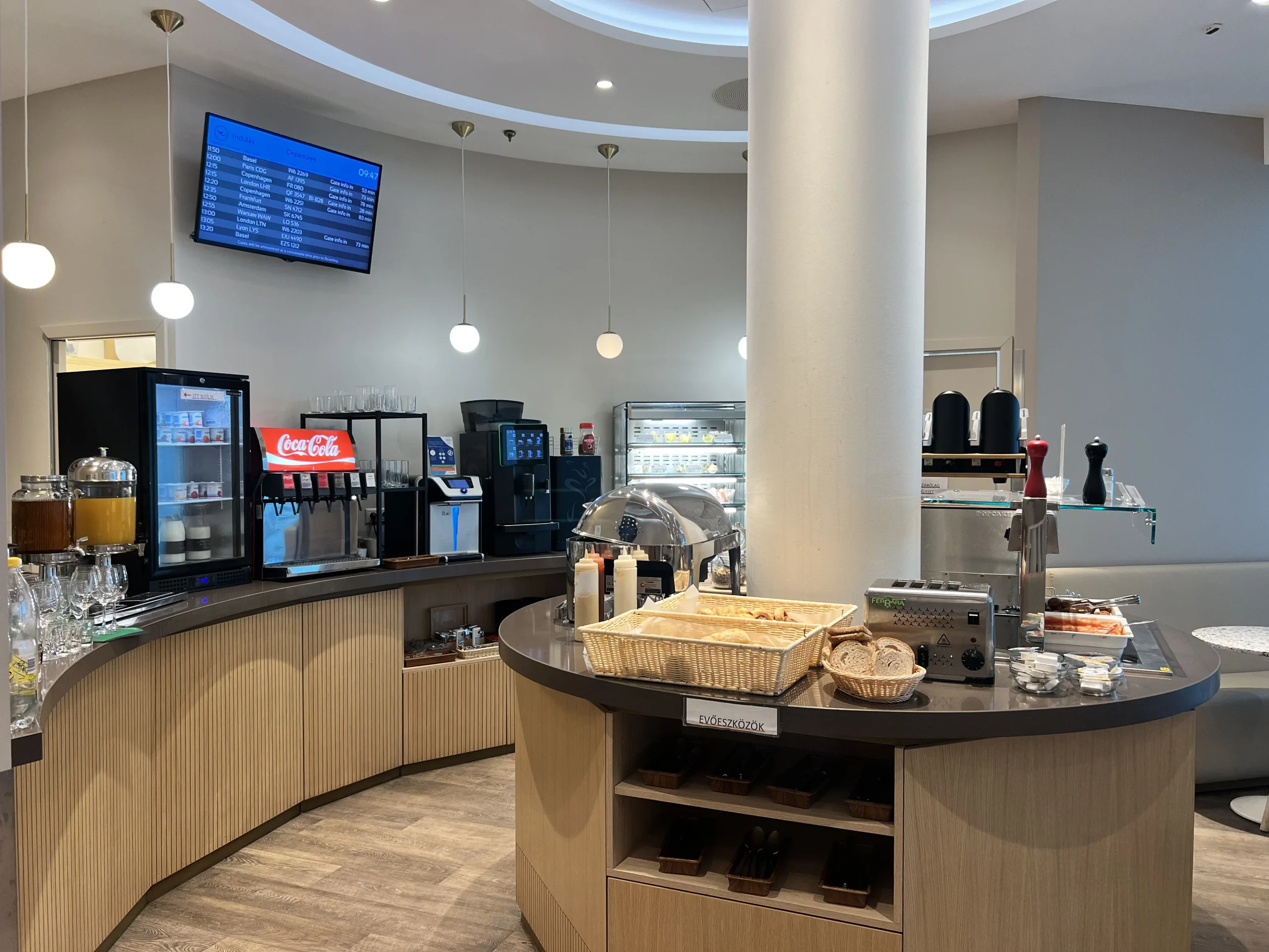 Buffet counter with pastries, bread, coffee machine and soft drinks at the Mastercard Airport Lounge Budapest